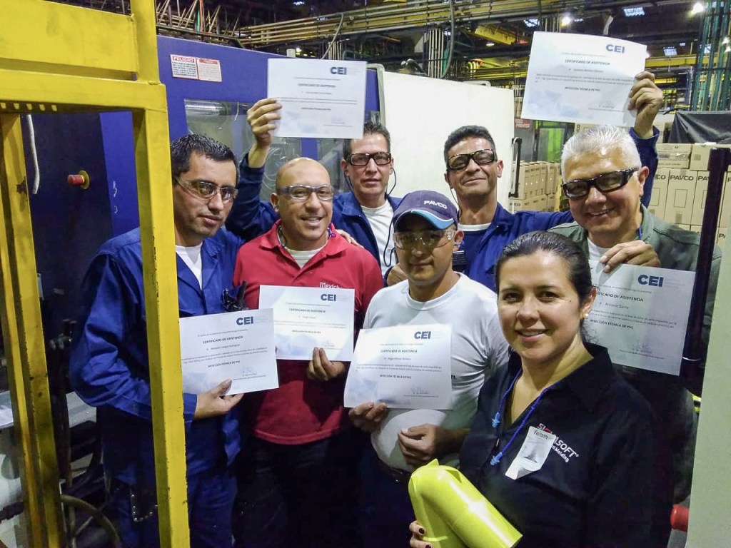 Participantes de una capacitación técnica en una planta de transformación de plásticos mostrando sus certificados del CEI.