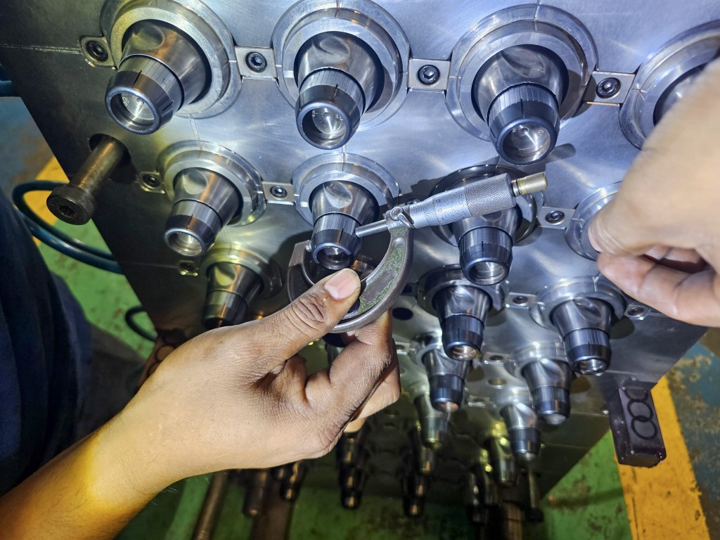 Inspección dimensional especializada de componentes de un molde de inyección utilizando un micrómetro.
